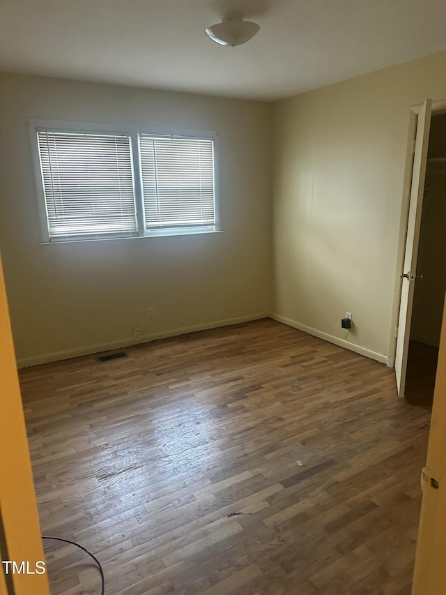 unfurnished room with dark hardwood / wood-style flooring