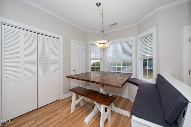 dining room featuring light wood-type flooring and crown molding