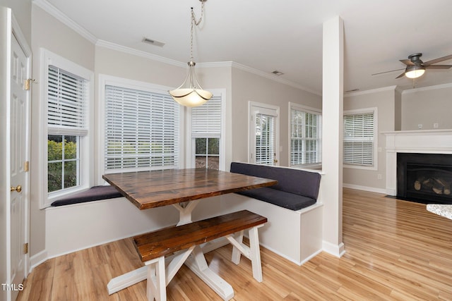 dining area with crown molding, light hardwood / wood-style flooring, and ceiling fan