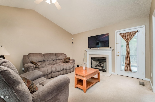 carpeted living room featuring ceiling fan and lofted ceiling