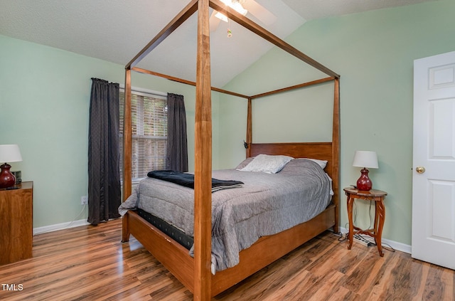 bedroom with vaulted ceiling, ceiling fan, a textured ceiling, and wood-type flooring