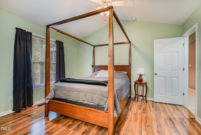 bedroom with ceiling fan, vaulted ceiling, and hardwood / wood-style flooring