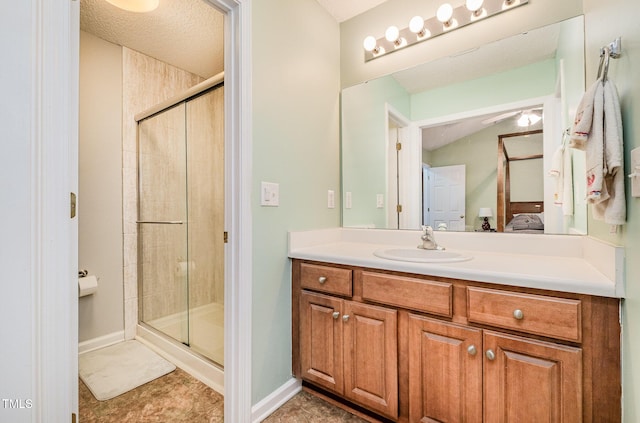 bathroom with vanity, a shower with door, and a textured ceiling