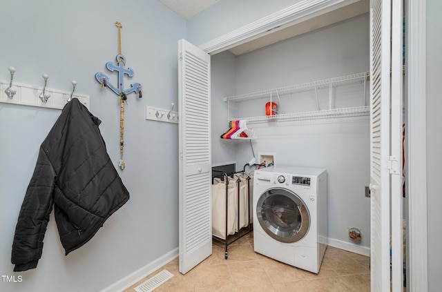 laundry room with light tile patterned floors and washer / dryer