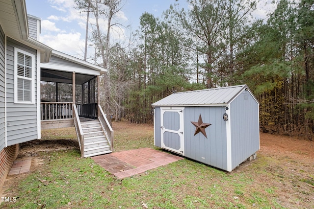 view of outdoor structure with a yard and a sunroom