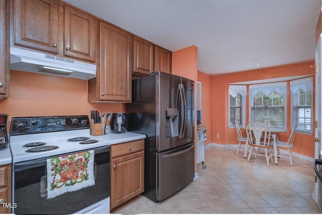 kitchen featuring light tile patterned floors, electric range, stainless steel fridge, and a textured ceiling