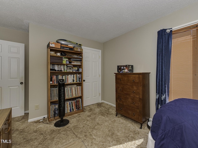 bedroom featuring light carpet and a textured ceiling