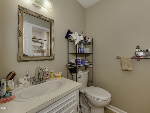 bathroom with vanity, a textured ceiling, and toilet