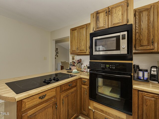 kitchen with kitchen peninsula and black appliances