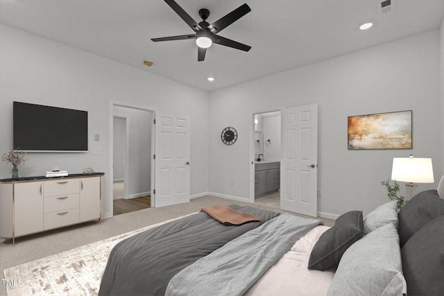 carpeted bedroom with connected bathroom, ceiling fan, and sink