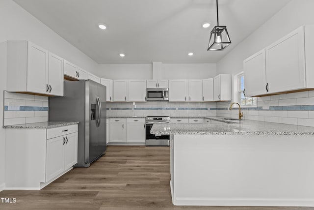 kitchen featuring sink, hanging light fixtures, light hardwood / wood-style flooring, white cabinets, and appliances with stainless steel finishes