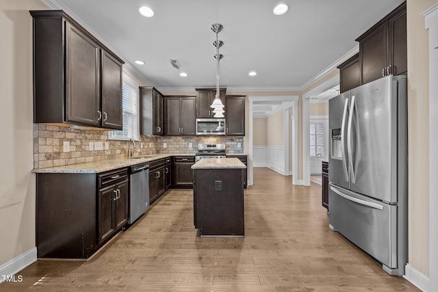 kitchen featuring a center island, sink, hanging light fixtures, light hardwood / wood-style flooring, and stainless steel appliances