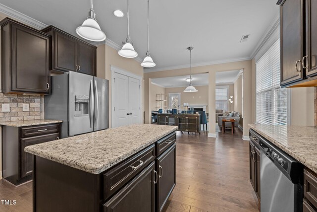 kitchen with a center island, dark hardwood / wood-style floors, crown molding, pendant lighting, and appliances with stainless steel finishes