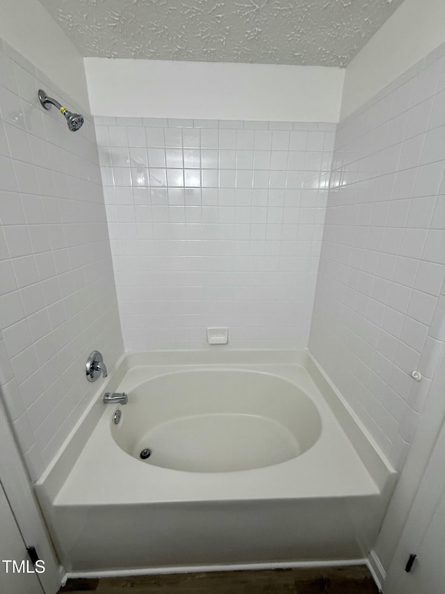 bathroom featuring a textured ceiling and  shower combination