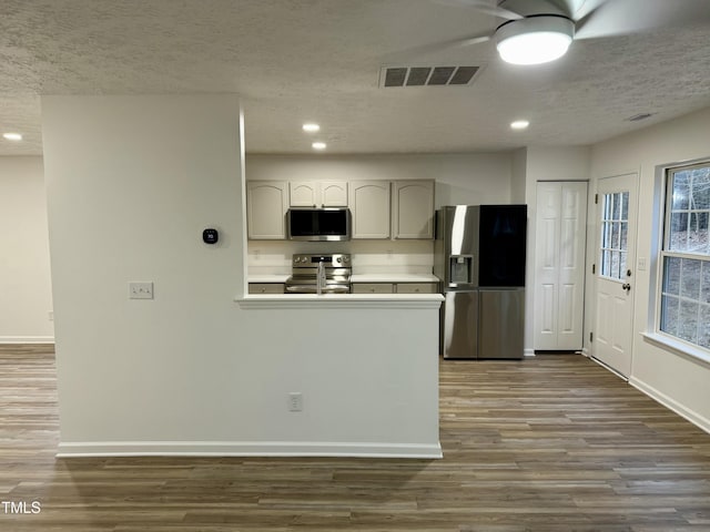 2816 Smoke Pl, Raleigh, NC 27610 - kitchen featuring stainless steel appliances, dark wood-style floors, ceiling fan, recessed lighting, and a textured ceiling