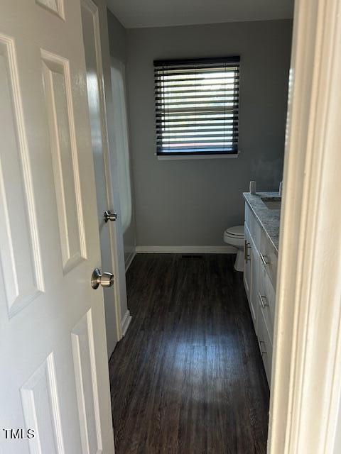 bathroom with toilet, vanity, and hardwood / wood-style flooring