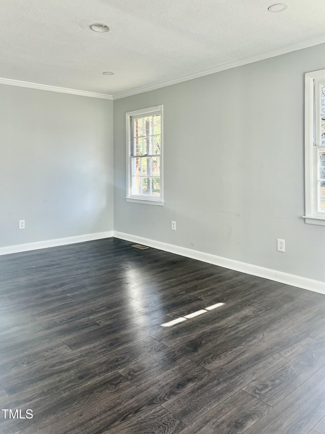 empty room featuring a textured ceiling, dark hardwood / wood-style floors, and ornamental molding