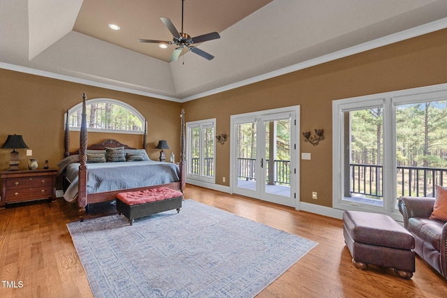 bedroom featuring french doors, access to outside, a raised ceiling, ceiling fan, and wood-type flooring