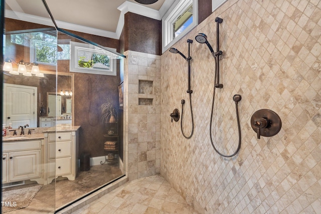 bathroom with tiled shower, vanity, and ornamental molding