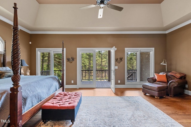 bedroom with hardwood / wood-style floors, ceiling fan, access to exterior, and a tray ceiling