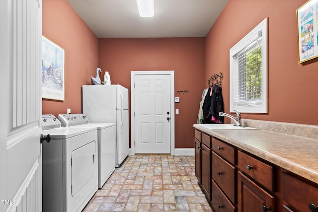 clothes washing area featuring cabinets, separate washer and dryer, and sink