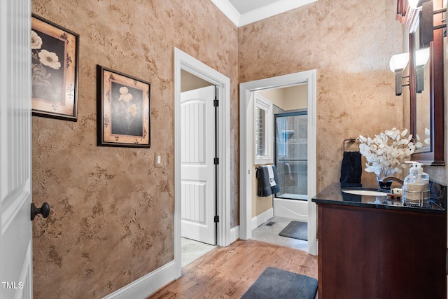 bathroom with vanity, combined bath / shower with glass door, wood-type flooring, and ornamental molding