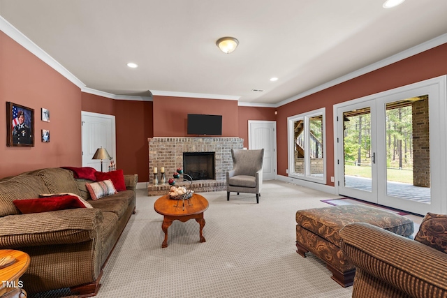 carpeted living room with french doors, crown molding, and a brick fireplace