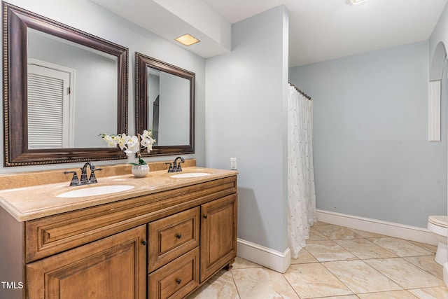 bathroom with toilet, vanity, and tile patterned floors