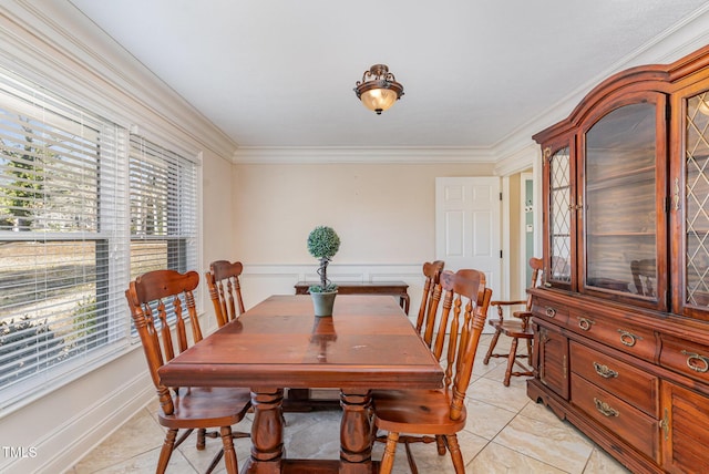 dining space with light tile patterned floors and ornamental molding