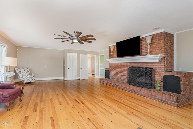 unfurnished living room with ceiling fan, a fireplace, ornamental molding, and hardwood / wood-style floors