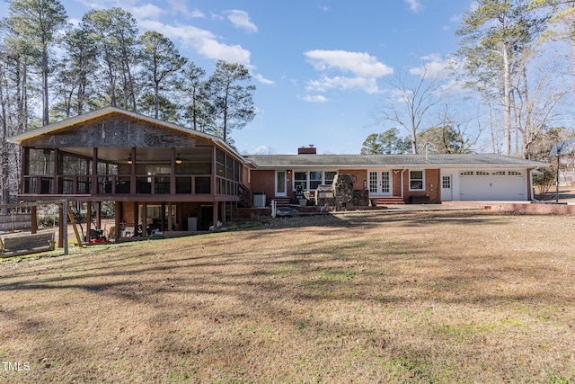 view of front facade with a front yard, a garage, and a sunroom