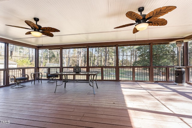 unfurnished sunroom with ceiling fan