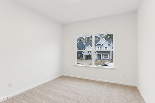 carpeted spare room with baseboards