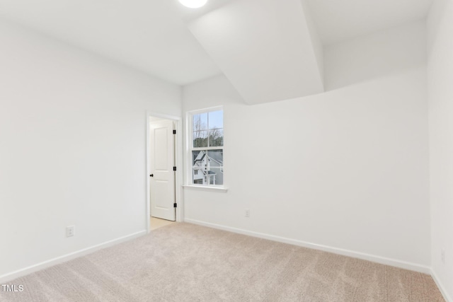 spare room with light carpet and baseboards