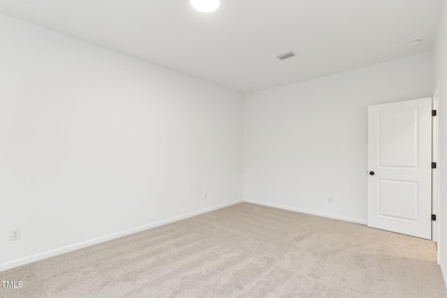 unfurnished room featuring baseboards, visible vents, and light colored carpet