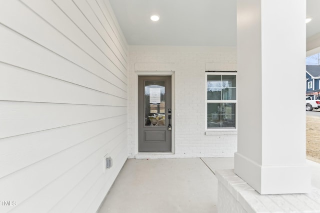 doorway to property featuring brick siding