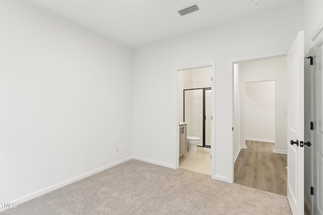 unfurnished bedroom with baseboards, visible vents, and light colored carpet