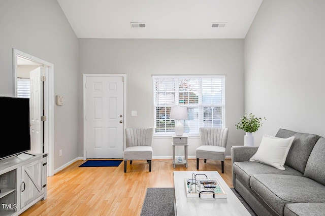 living room featuring wood-type flooring and vaulted ceiling