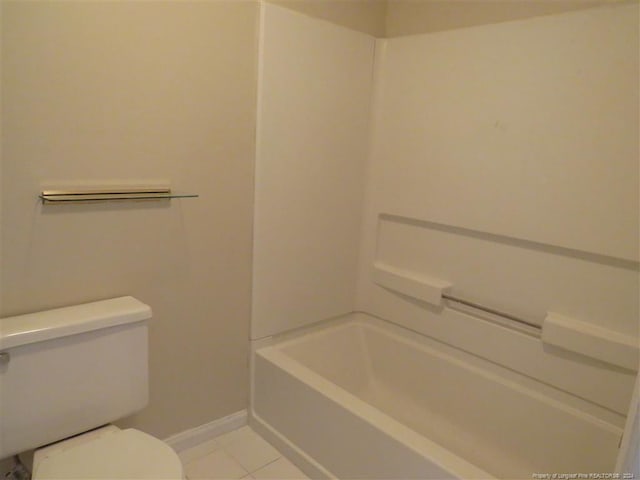 bathroom with tile patterned flooring, a bathtub, and toilet