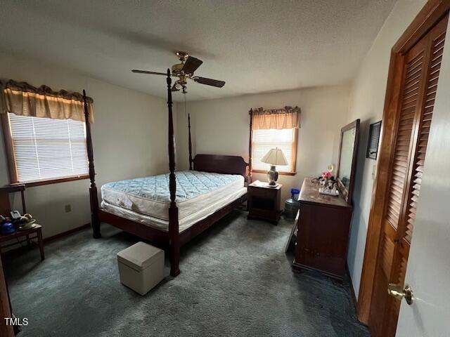 carpeted bedroom featuring ceiling fan and a textured ceiling