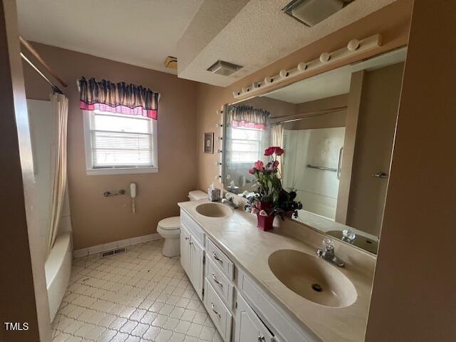 full bathroom featuring toilet, vanity, and shower / bath combo with shower curtain