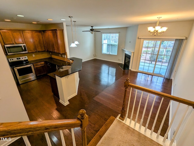 kitchen featuring appliances with stainless steel finishes, dark hardwood / wood-style flooring, decorative light fixtures, and sink