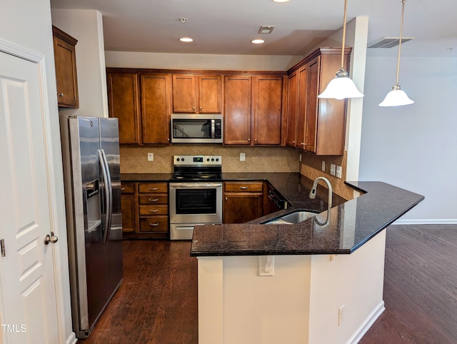 kitchen featuring sink, kitchen peninsula, stainless steel appliances, and dark wood-type flooring