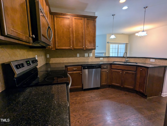 kitchen with pendant lighting, dark hardwood / wood-style floors, sink, and stainless steel appliances