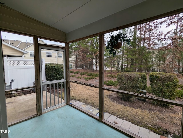 unfurnished sunroom featuring vaulted ceiling