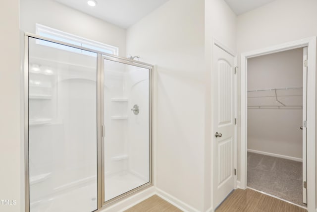 bathroom featuring wood-type flooring and a shower with door