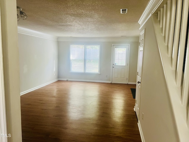 empty room with hardwood / wood-style flooring, crown molding, and a textured ceiling