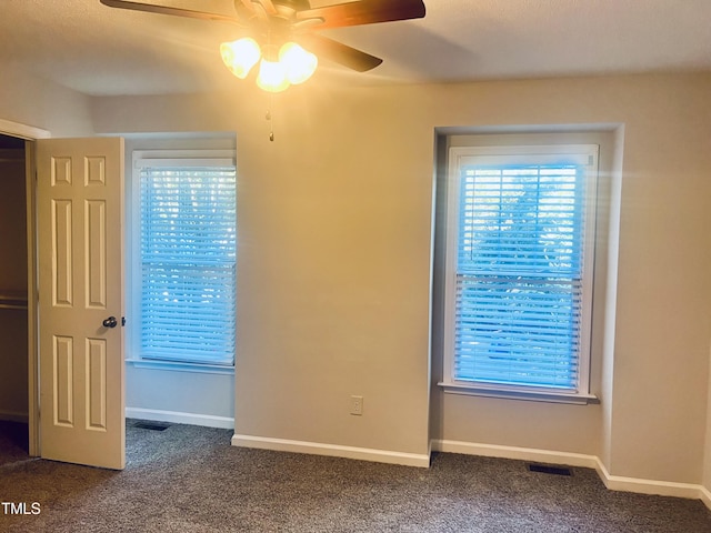 carpeted spare room featuring ceiling fan