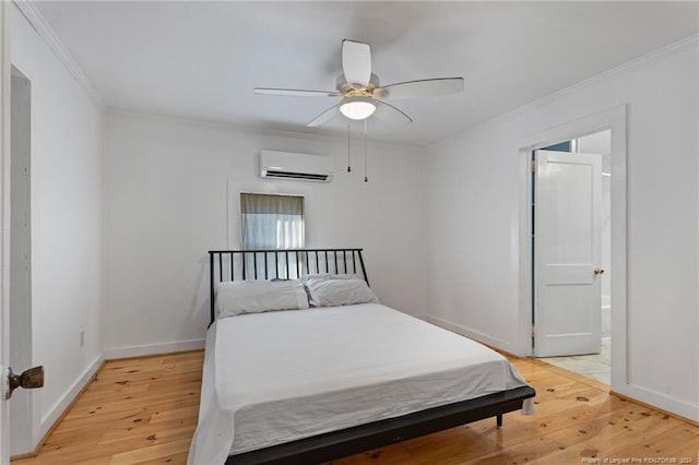 bedroom with connected bathroom, ceiling fan, a wall mounted air conditioner, crown molding, and hardwood / wood-style floors