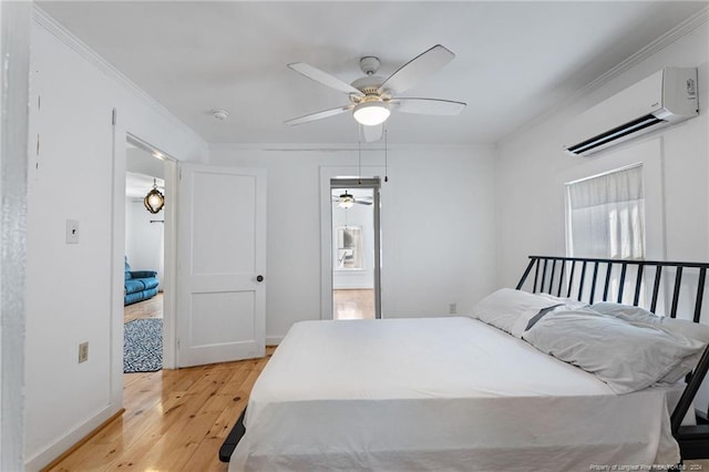 bedroom featuring ceiling fan, light wood-type flooring, crown molding, and a wall unit AC